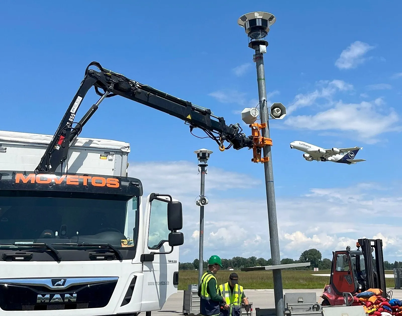 Aufbau am Flughafen München: Der Kran des MOVETOS-Lkw setzt einen Mast mit Kamera und Lautsprechern
