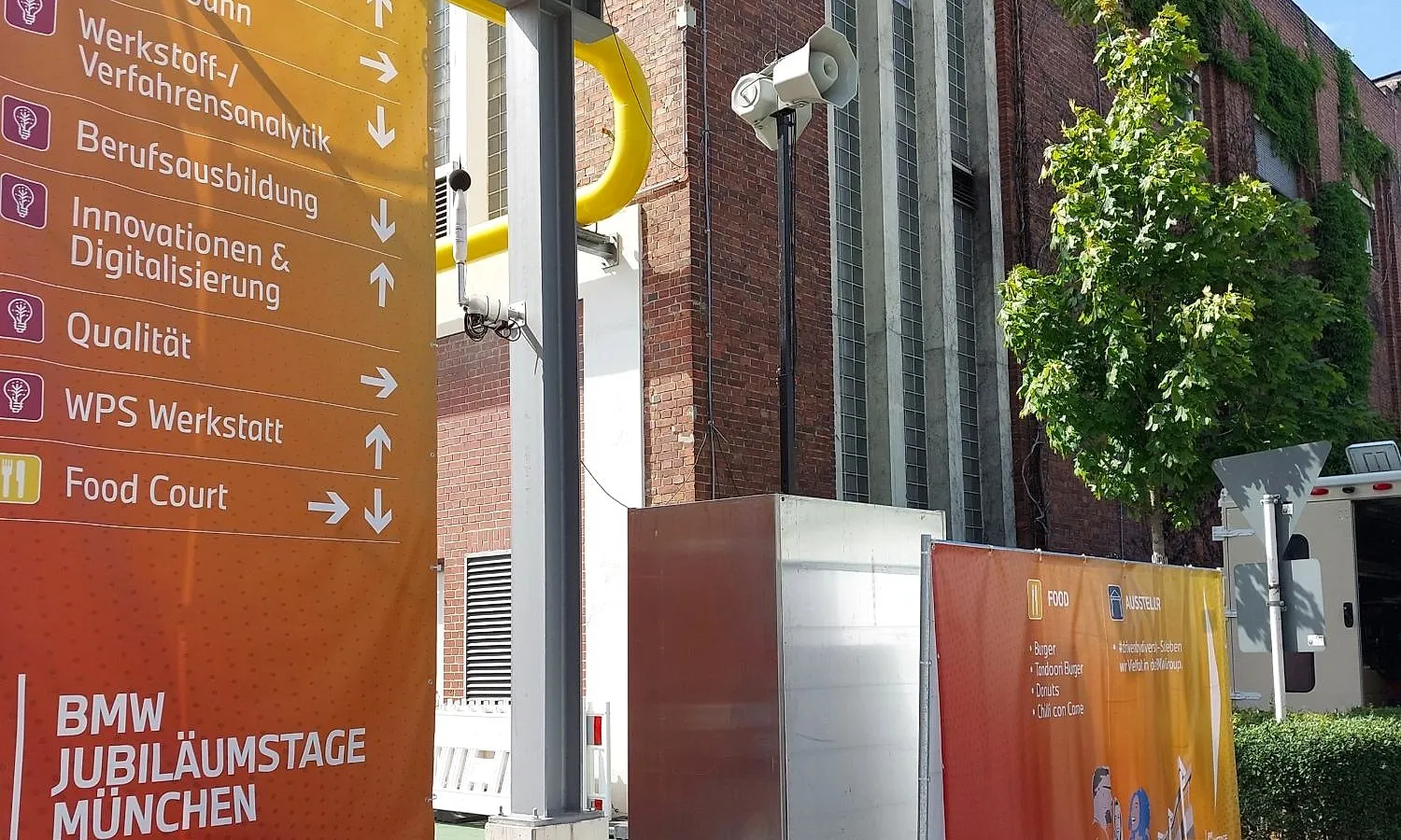 Visitor announcement system with loudspeaker on the BMW plant in Munich, next to the anniversary-day signage